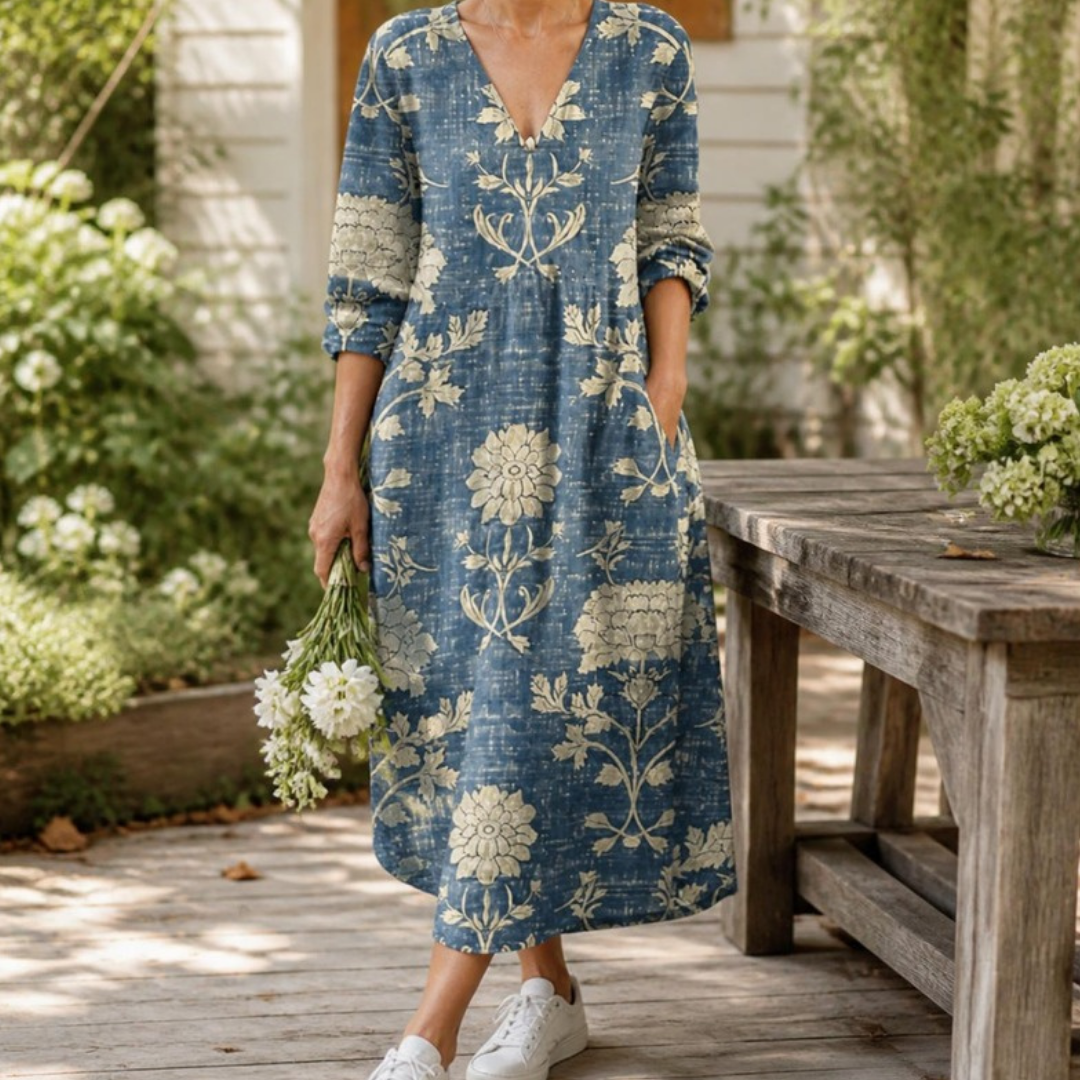 Winifred midi dress in Blue worn in a garden with white sneakers