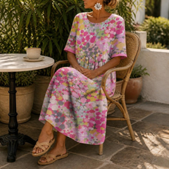Primrose midi dress in Pink — seated at an outdoor café table